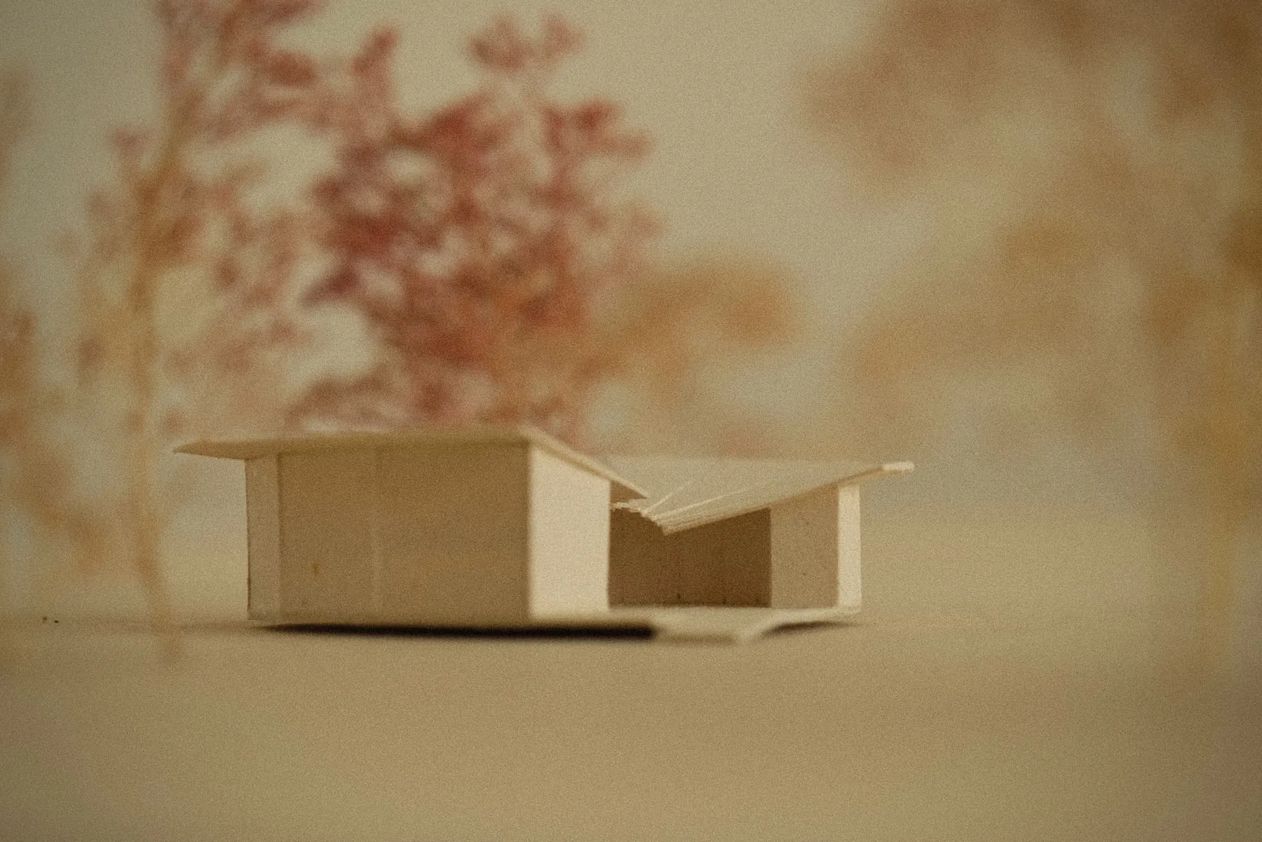 Second card massing model showing a small building with a folded plate roof over an open courtyard.